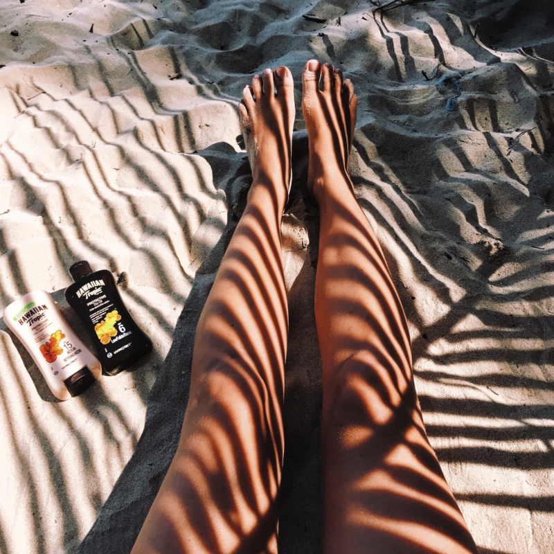 tanned legs unter palm tree