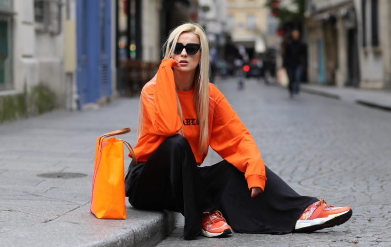 orange pablo sweatshirt, black pants, sunglasses, orange sneakers
