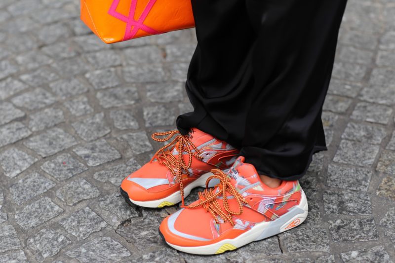 puma swash orange sneaker, schwarze hose, straße
