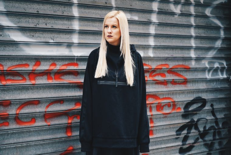 Palina, Grafitti, blonde Haare, schwarzer Oversize Pullover