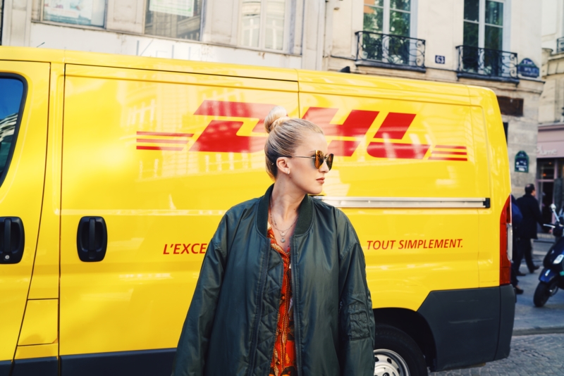 blonder dutt, sonnenbrille, grüne xxl bomberjacke, dhl truck, paris