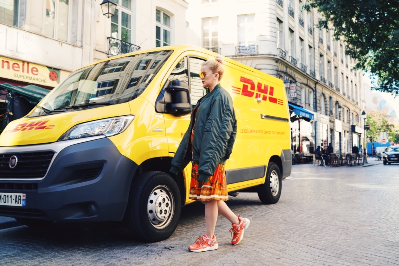 dhl truck, orange dress, green oversize bomber jacket, orange sneakers